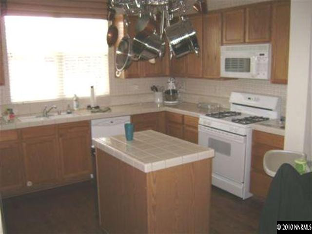 10211 Wolf Ridge Way Reno, NV 89521 - Photo 2 of 4 a kitchen with stainless steel appliances granite countertop a sink stove and cabinets