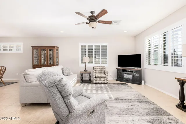 a living room with furniture a flat screen tv and a large window