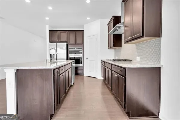 a kitchen with stainless steel appliances granite countertop a stove a sink and a refrigerator