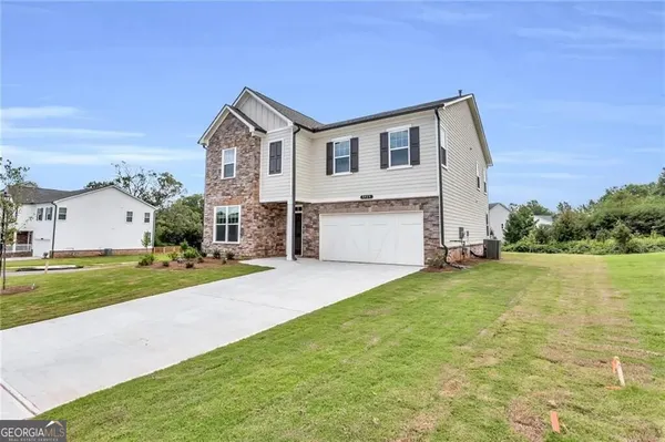 a view of a house with a yard and a garage