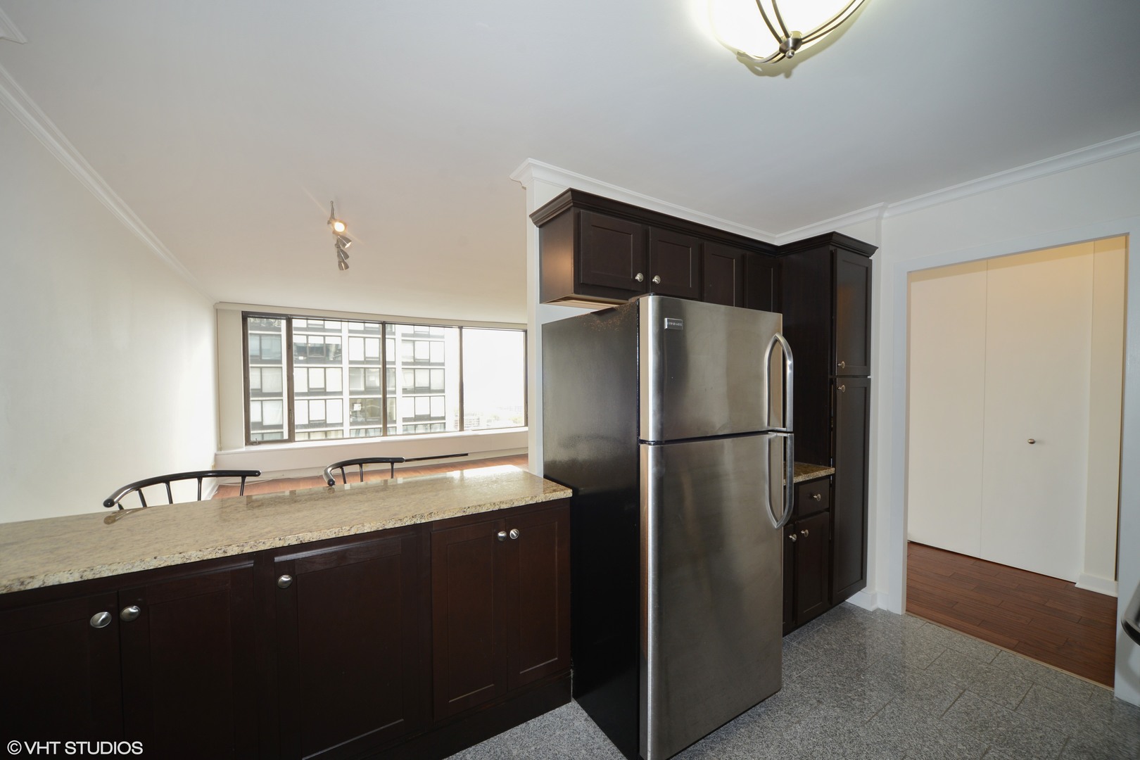 5455 North Sheridan Road, Unit 2810 Chicago, IL 60640 - Photo 4 of 9 a kitchen with a sink cabinets and refrigerator