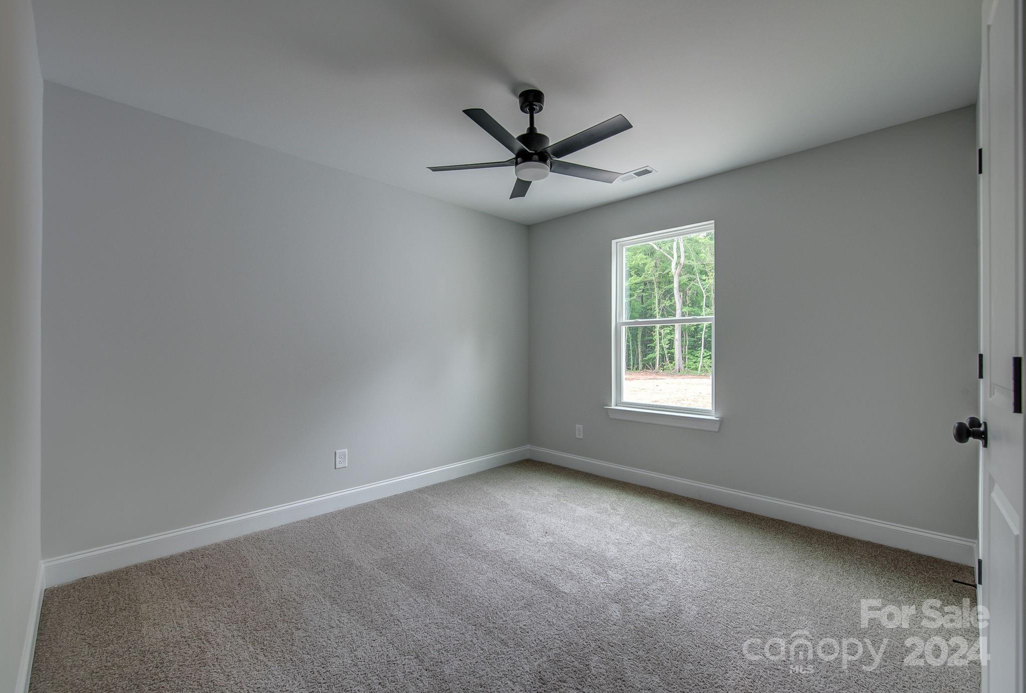 525 Blacksnake Road Stanley, NC 28164 - Photo 15 of 21 an empty room with windows and fan