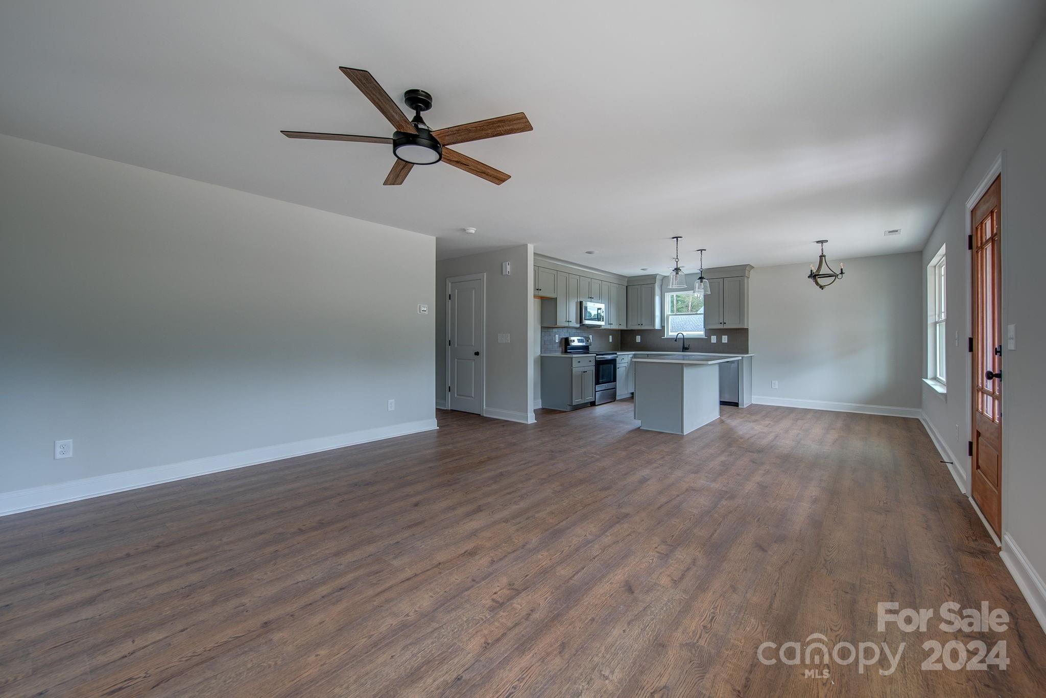525 Blacksnake Road Stanley, NC 28164 - Photo 9 of 21 a view of a kitchen with a wooden floor and a ceiling fan