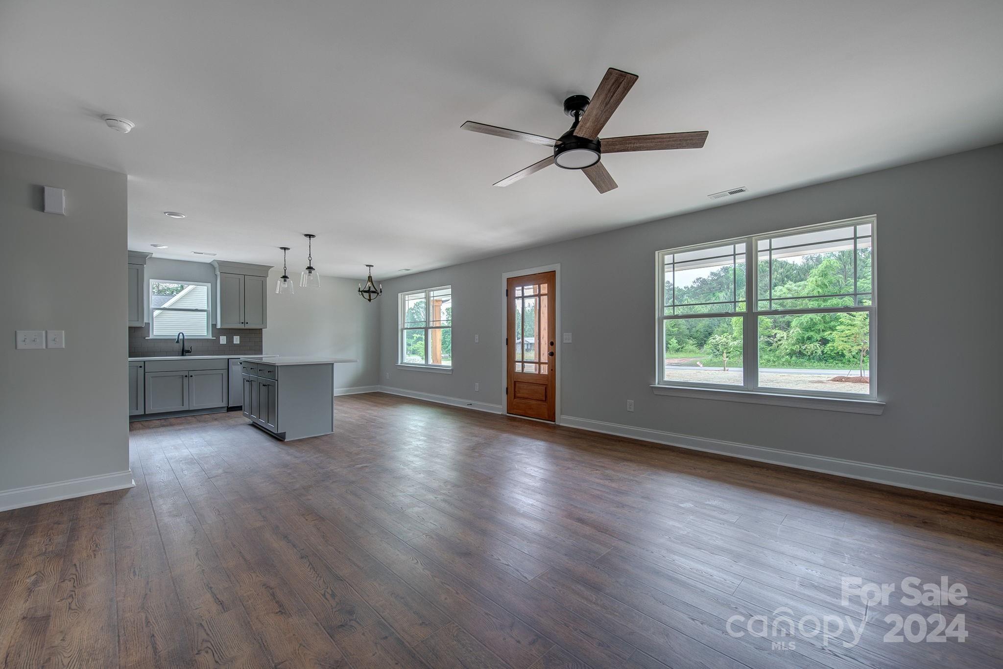 525 Blacksnake Road Stanley, NC 28164 - Photo 10 of 21 a view of a kitchen and an empty room with wooden floor and a window