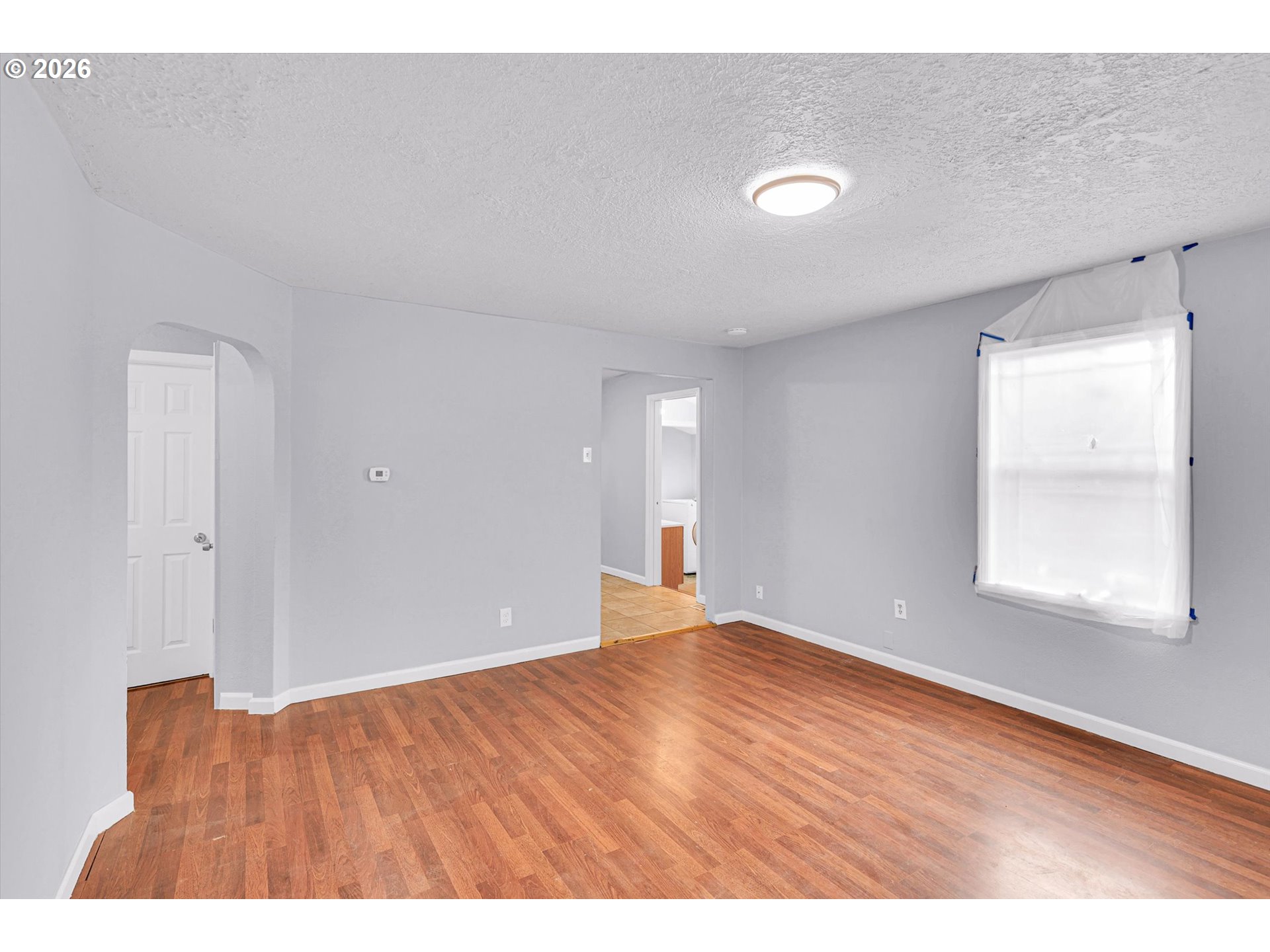 14125 Southeast Division Street Portland, OR 97233 - Photo 6 of 17 a view of an empty room with wooden floor and a window