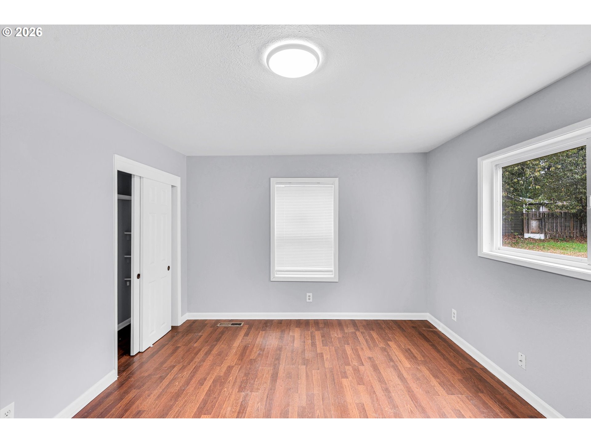 14125 Southeast Division Street Portland, OR 97233 - Photo 10 of 17 a view of an empty room with wooden floor and a window