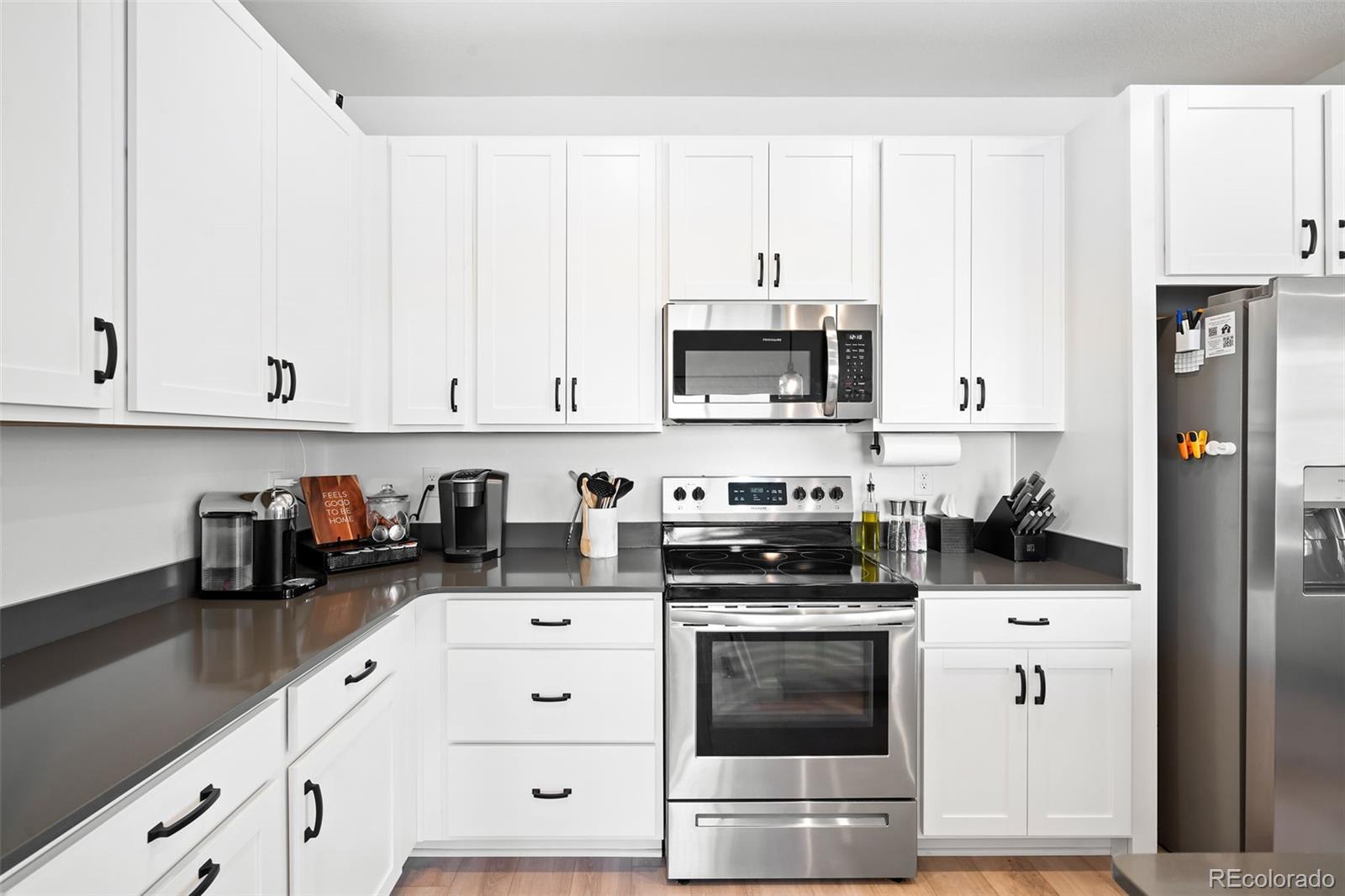 16249 Laurentide Place Parker, CO 80134 - Photo 11 of 30 a kitchen with white cabinets and appliances