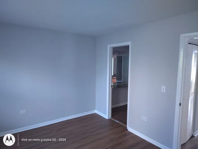 a view of an empty room with wooden floor & closet