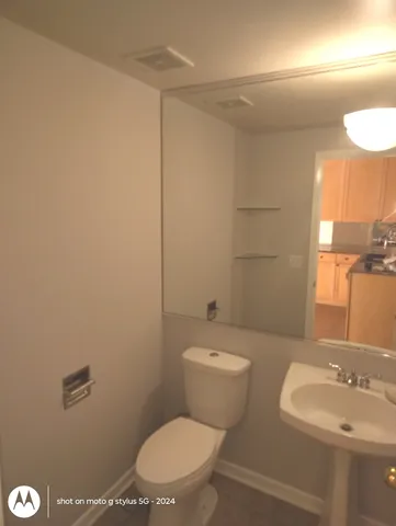 a bathroom with a toilet a sink and mirror