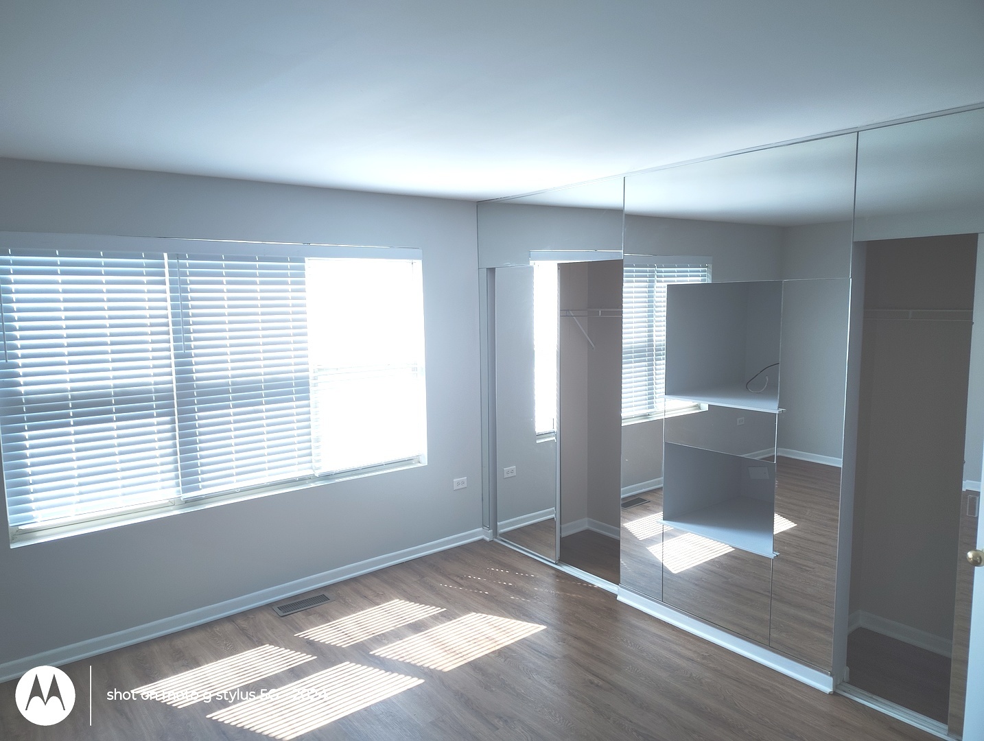 2367 East 70th Place, Unit 1A Chicago, IL 60649 - Photo 9 of 30 a view of an empty room with a window and wooden floor