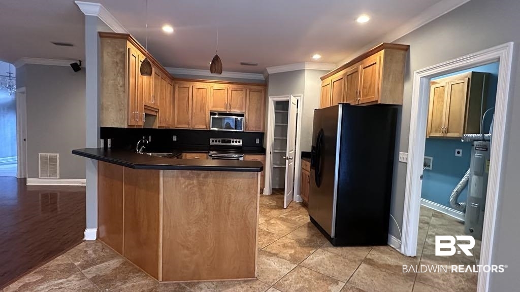 23289 McPhillips Road Loxley, AL 36551 - Photo 5 of 19 Kitchen featuring light wood cabinetry, dark countertops, and stainless steel appliances