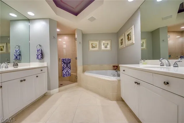 a spacious bathroom with a double vanity sink a mirror and a bathtub