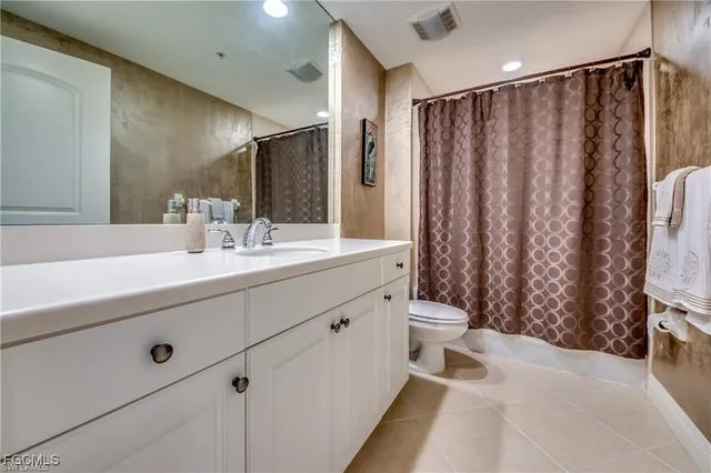 a bathroom with a double vanity sink toilet and shower