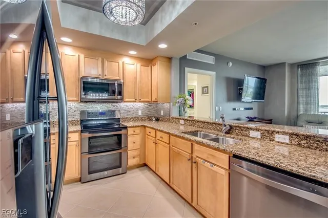 a kitchen with stainless steel appliances granite countertop a sink and a stove