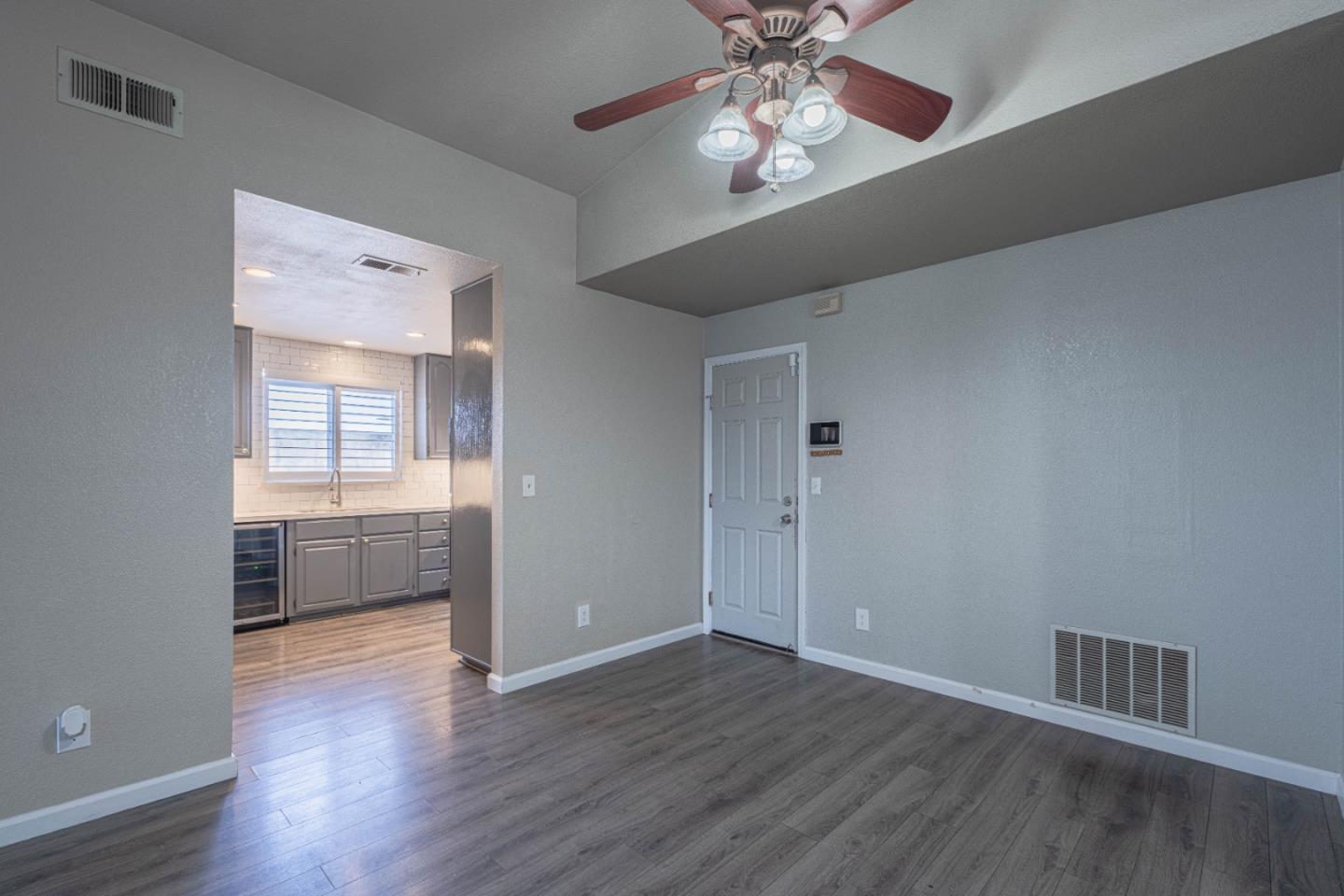 890 Sloat Drive Salinas, CA 93907 - Photo 8 of 37 an empty room with wooden floor chandelier fan and windows