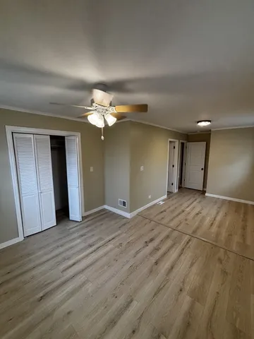 a view of an empty room with wooden floor