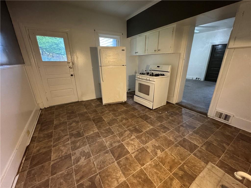 221 Singer Avenue McKees Rocks, PA 15136 - Photo 5 of 23 a kitchen with granite countertop a stove a sink and a refrigerator