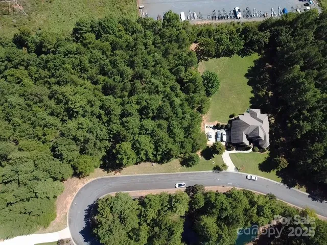 an aerial view of a house with a yard and lake view