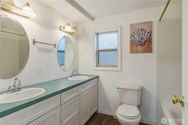 a bathroom with a toilet a sink and mirror