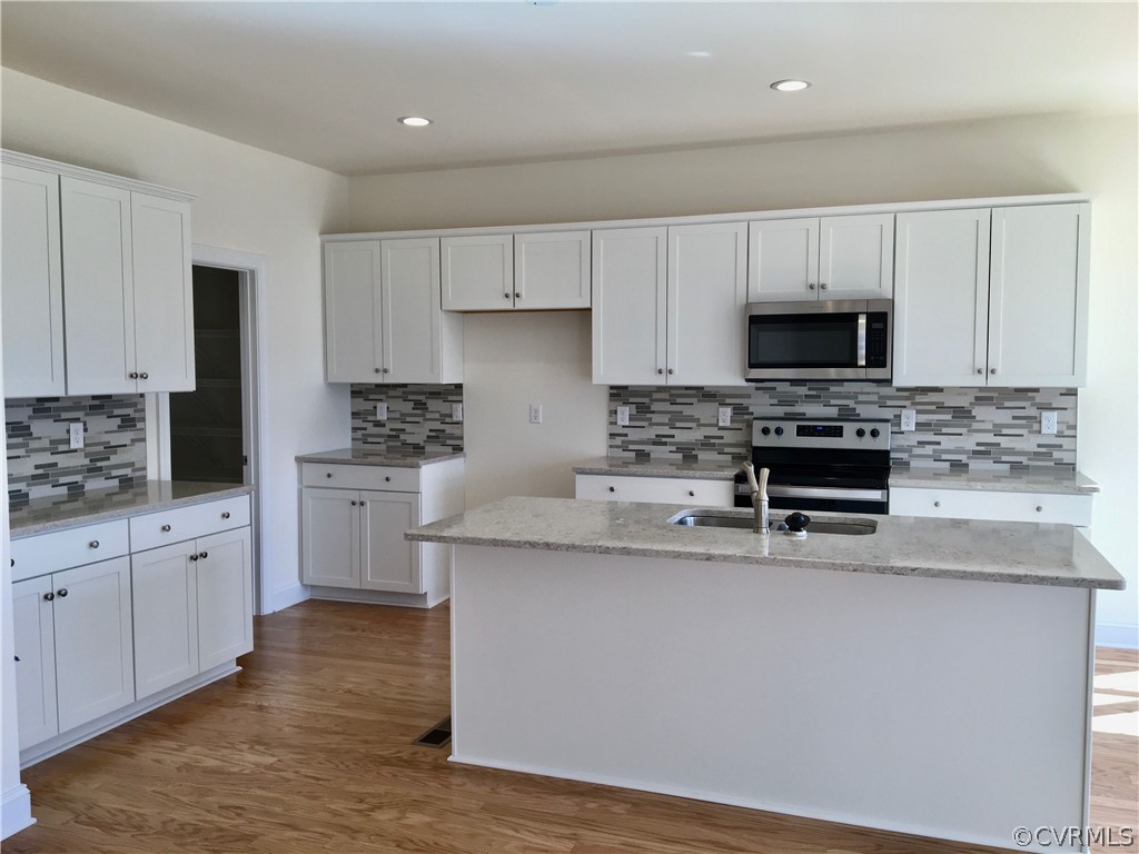 8423 Bishops Park Drive Mechanicsville, VA 23116 - Photo 6 of 17 a kitchen with stainless steel appliances a sink a stove a microwave a refrigerator a sink and white cabinets