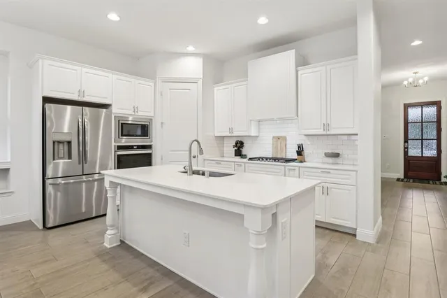 a kitchen with stainless steel appliances a refrigerator sink and microwave