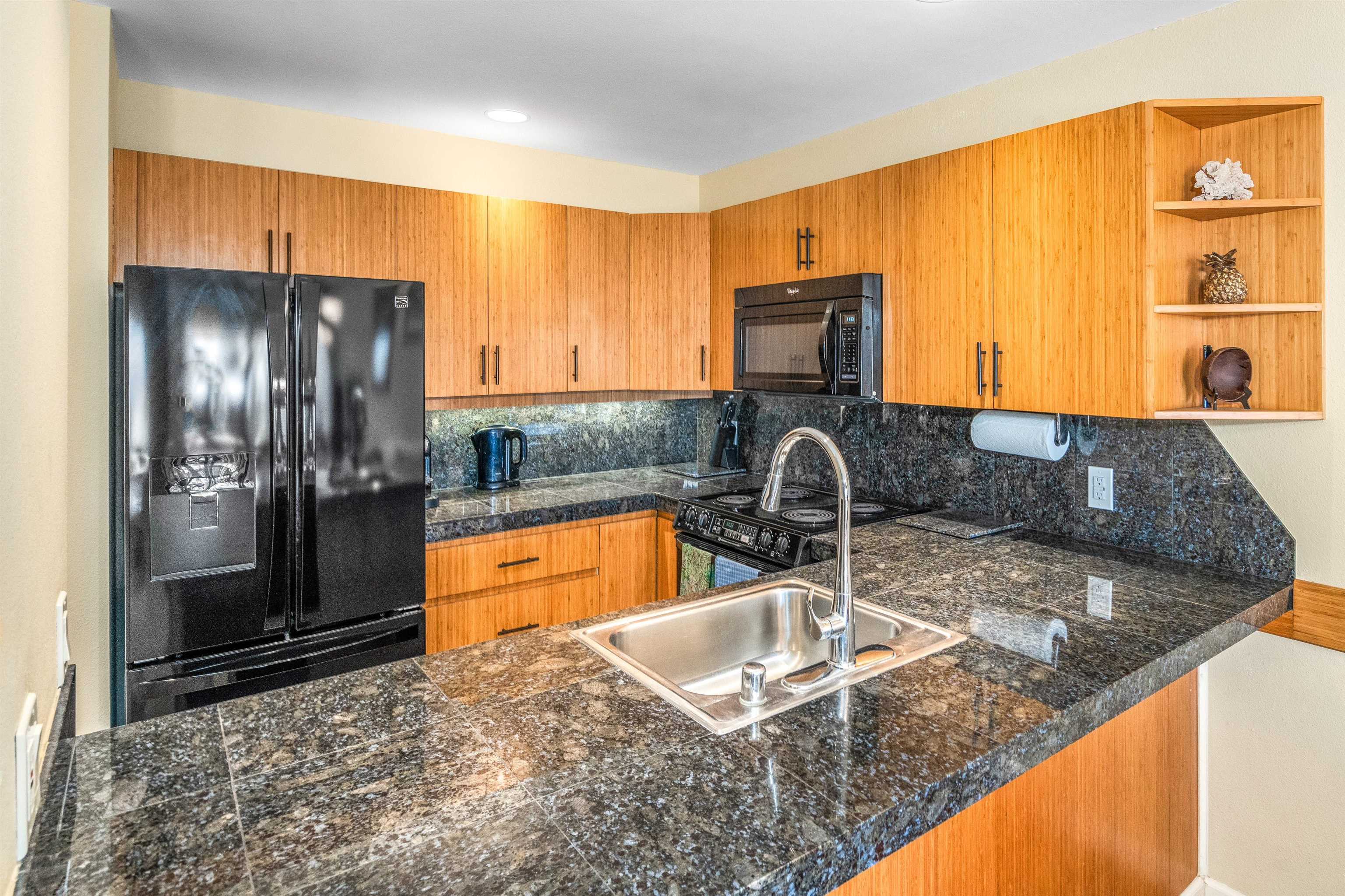 2777 South Kihei Road, Unit G207 Kihei, HI 96753 - Photo 11 of 50 a kitchen with stainless steel appliances granite countertop a sink and a refrigerator