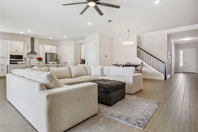 a kitchen with stainless steel appliances a refrigerator a stove a sink and white cabinets with wooden floor