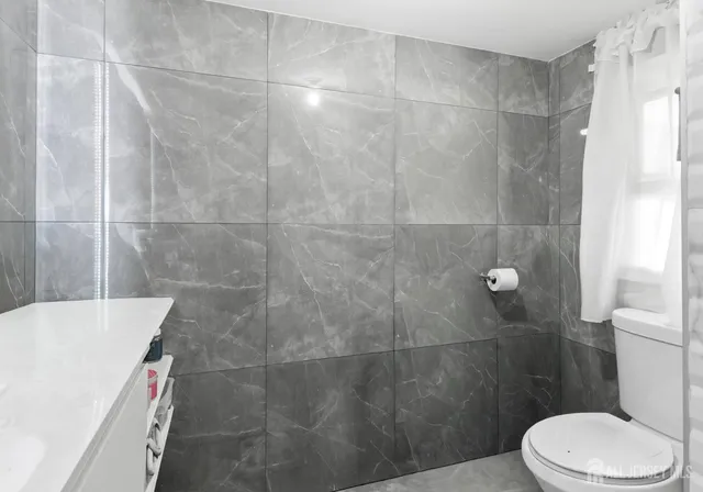 a bathroom with a white toilet and shower