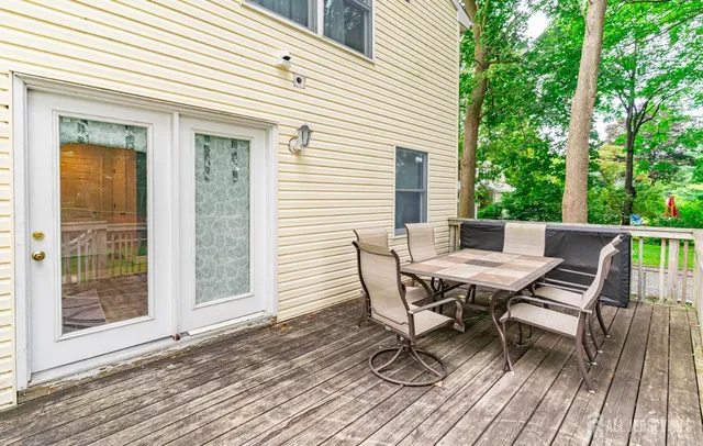 a view of a roof deck with table and chairs and wooden floor