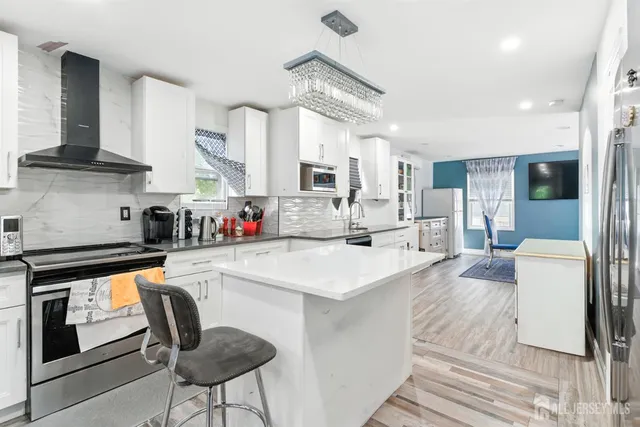 a large kitchen with stainless steel appliances lots of white cabinets
