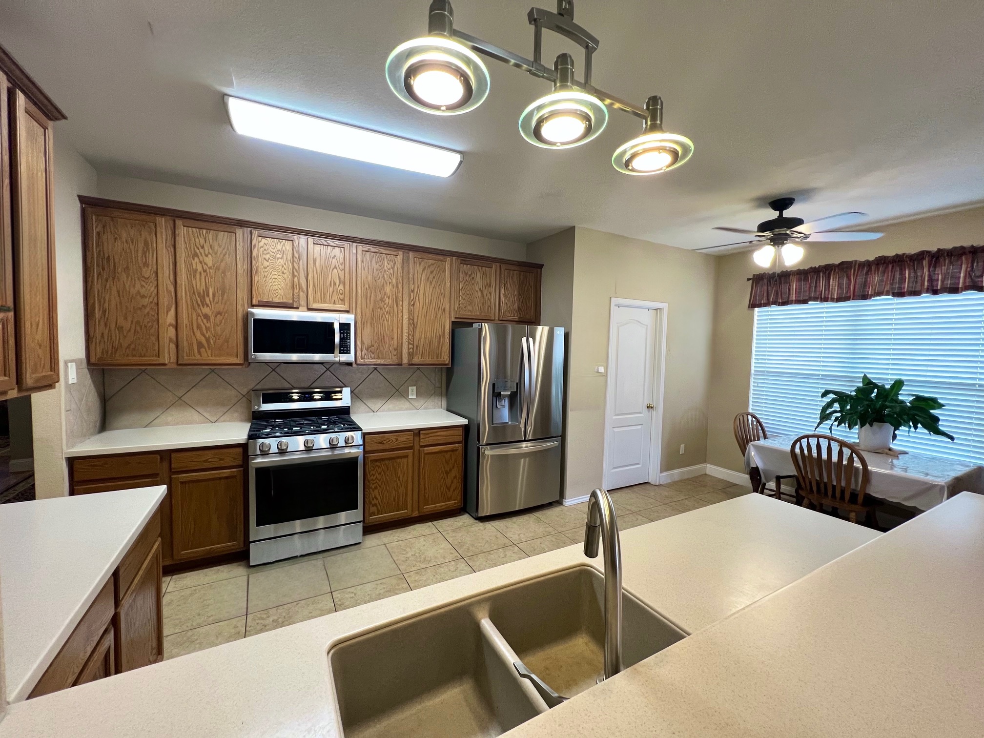 17705 Mahonia Lane Elgin, TX 78621 - Photo 12 of 35 a kitchen with stainless steel appliances kitchen island granite countertop a refrigerator a stove a sink and a stove