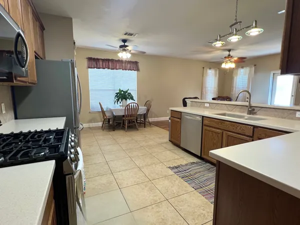 a kitchen with stainless steel appliances granite countertop a refrigerator sink and stove