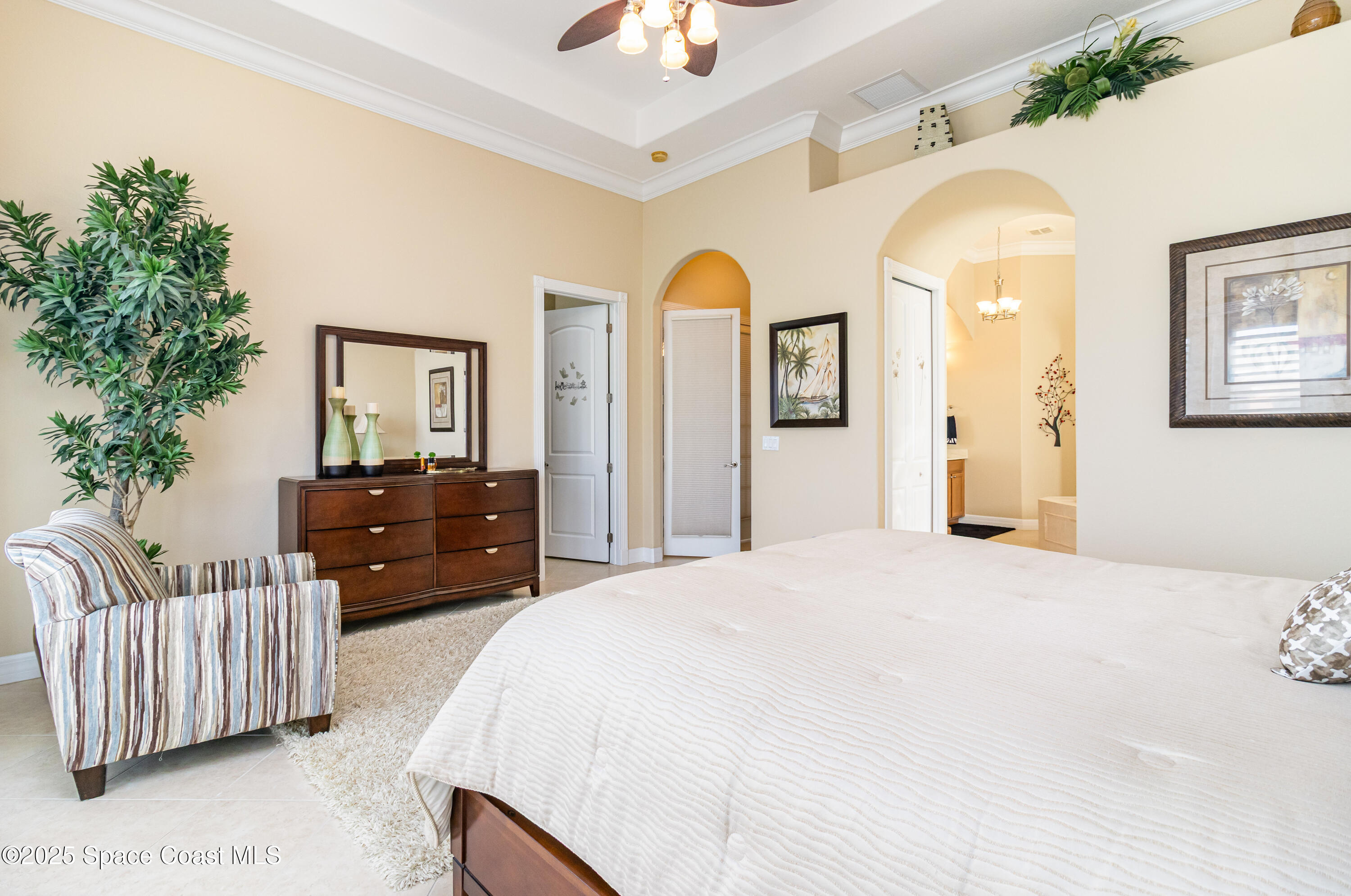 200 Harmony Lane Titusville, FL 32780 - Photo 18 of 28 a bedroom with a bed and a chandelier
