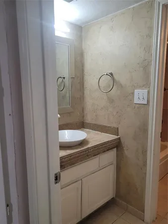 a bathroom with a granite countertop sink a vanity and shower