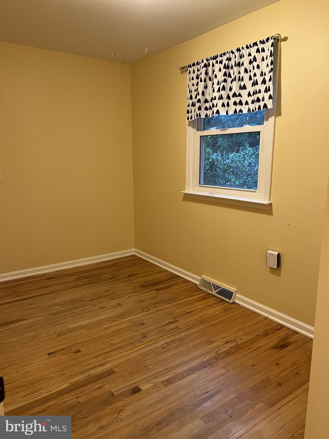 104 Cedar Street Chestertown, MD 21620 - Photo 11 of 14 a view of an empty room with wooden floor and a window