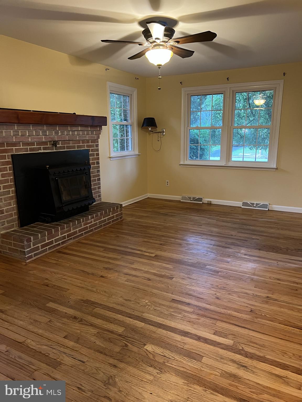 104 Cedar Street Chestertown, MD 21620 - Photo 10 of 14 an empty room with wooden floor fireplace and windows