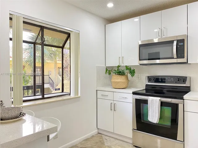 a kitchen with stainless steel appliances white cabinets and a stove top oven