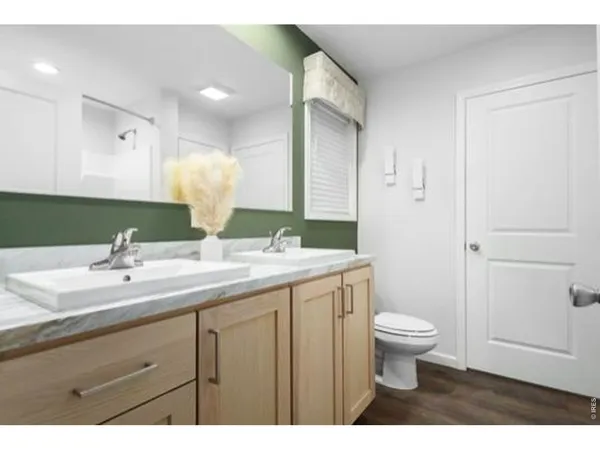 a bathroom with a granite countertop sink a toilet and a mirror