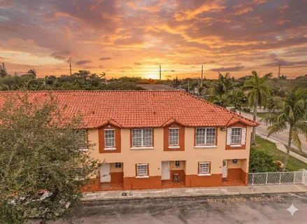 a view of a white house next to a yard and lake