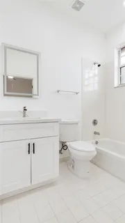 a bathroom with a toilet a sink a mirror and vanity