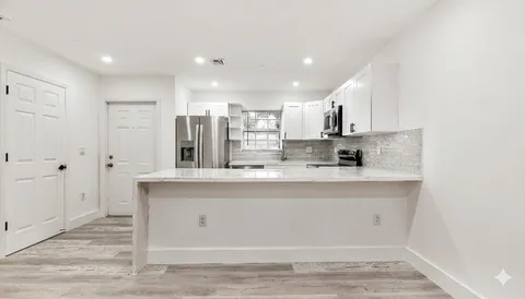 a view of kitchen with stainless steel appliances granite countertop cabinets and sink