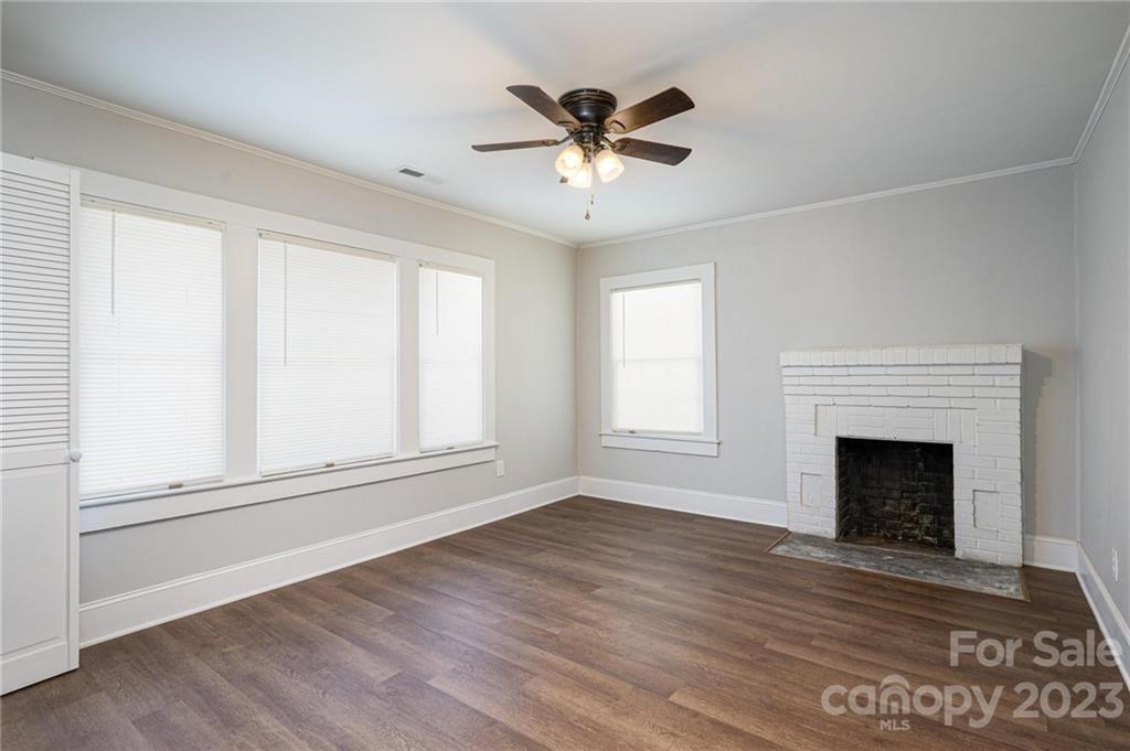 2496 Shoal Road Crouse, NC 28033 - Photo 14 of 29 an empty room with wooden floor fireplace and windows