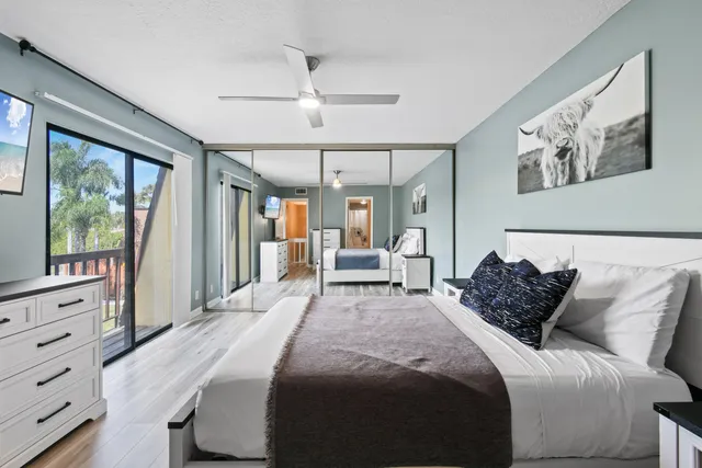 a bedroom with a large bed and a flat tv screen on dresser