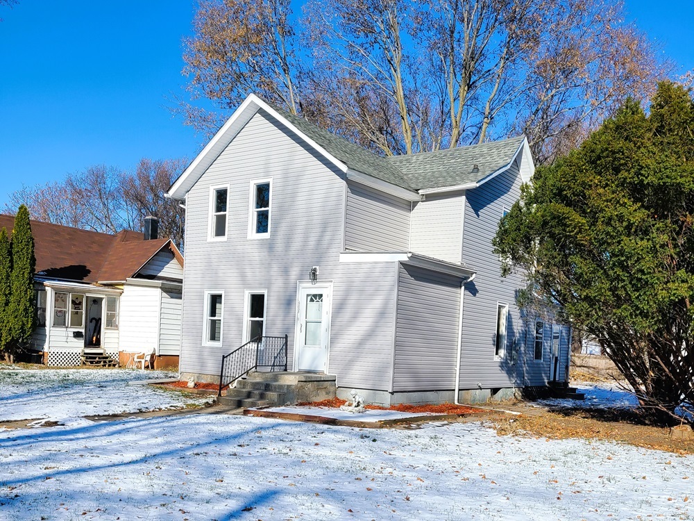 902 West 5th Street Sterling, IL 61081 - Photo 2 of 20 a view of a white house with large tree and wooden fence
