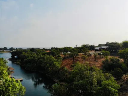 an aerial view of residential house with outdoor space and trees all around