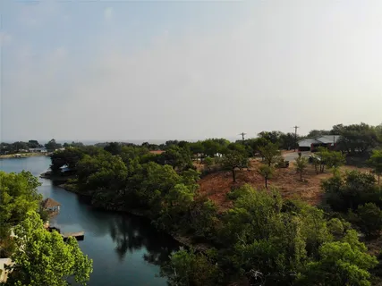 an aerial view of a house with a yard and lake view