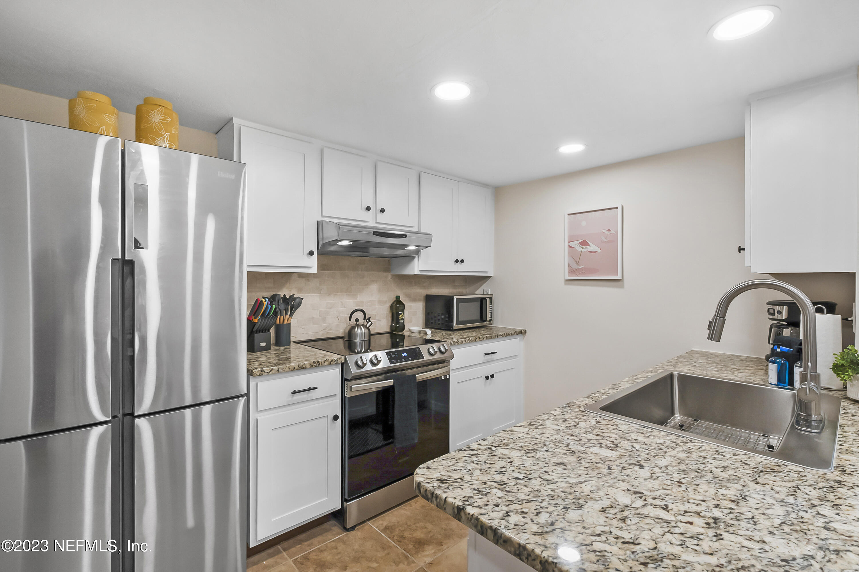 3905 Windjammer Lane St. Augustine, FL 32084 - Photo 12 of 40 a kitchen with stainless steel appliances granite countertop a refrigerator sink and stove