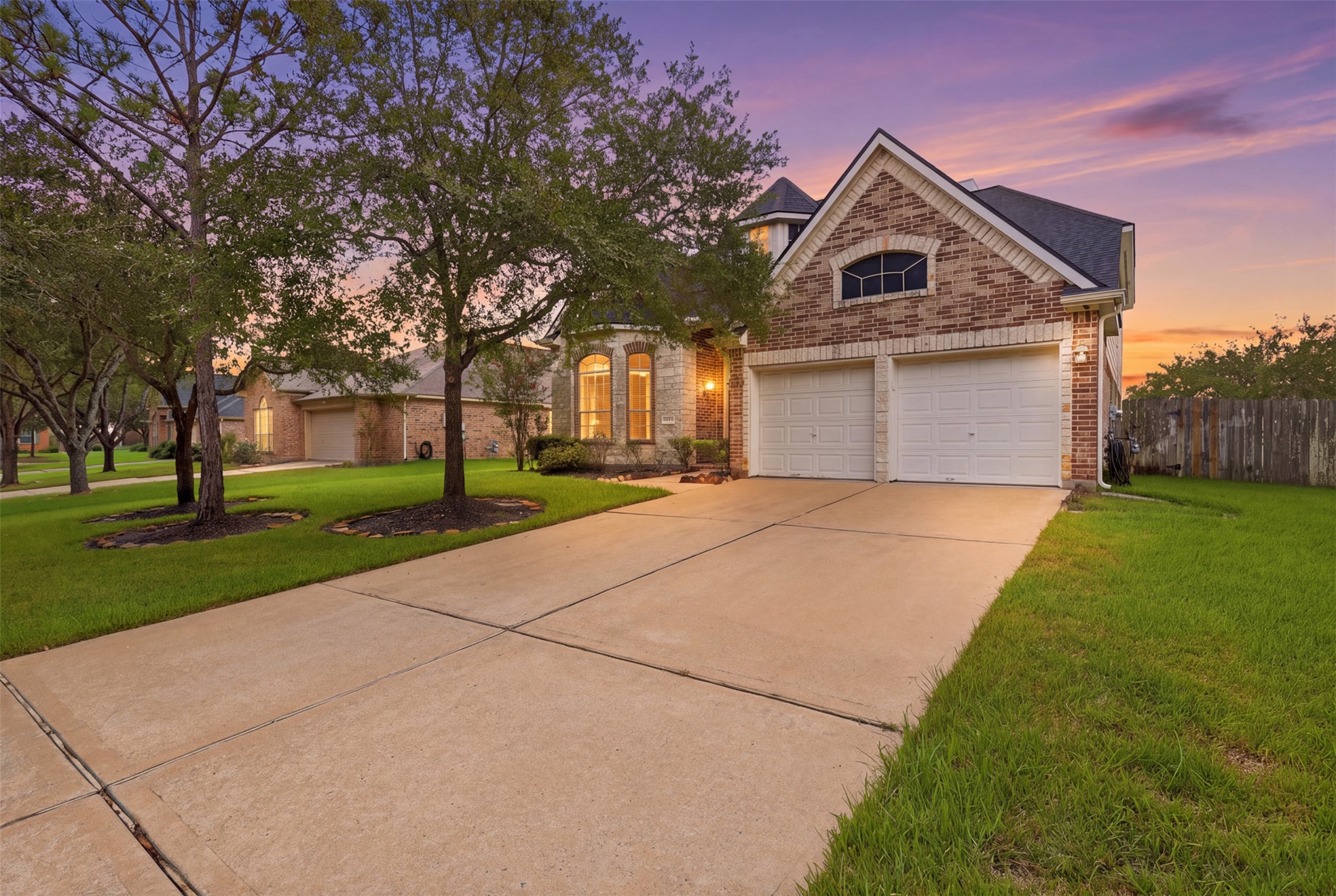 13806 Cove Landing Lane Rosharon, TX 77583 - Photo 4 of 44 Twilight views highlight the home’s warm exterior lighting, distinctive rooflines, and welcoming front elevation.