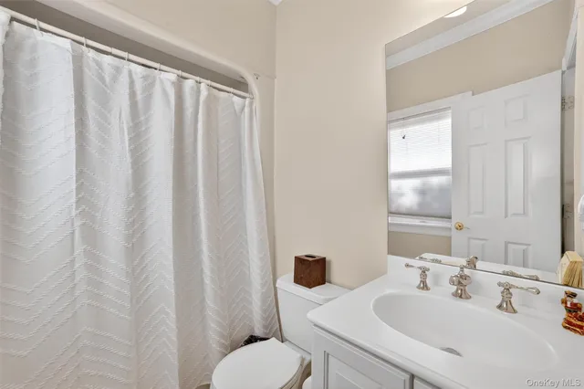 a bathroom with a sink mirror and toilet