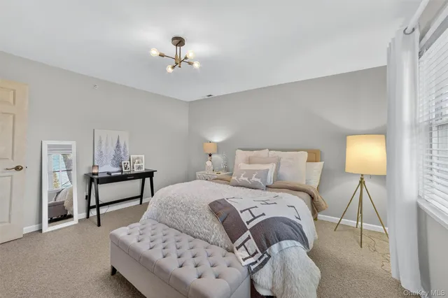 a bedroom with a bed gym equipment and large windows